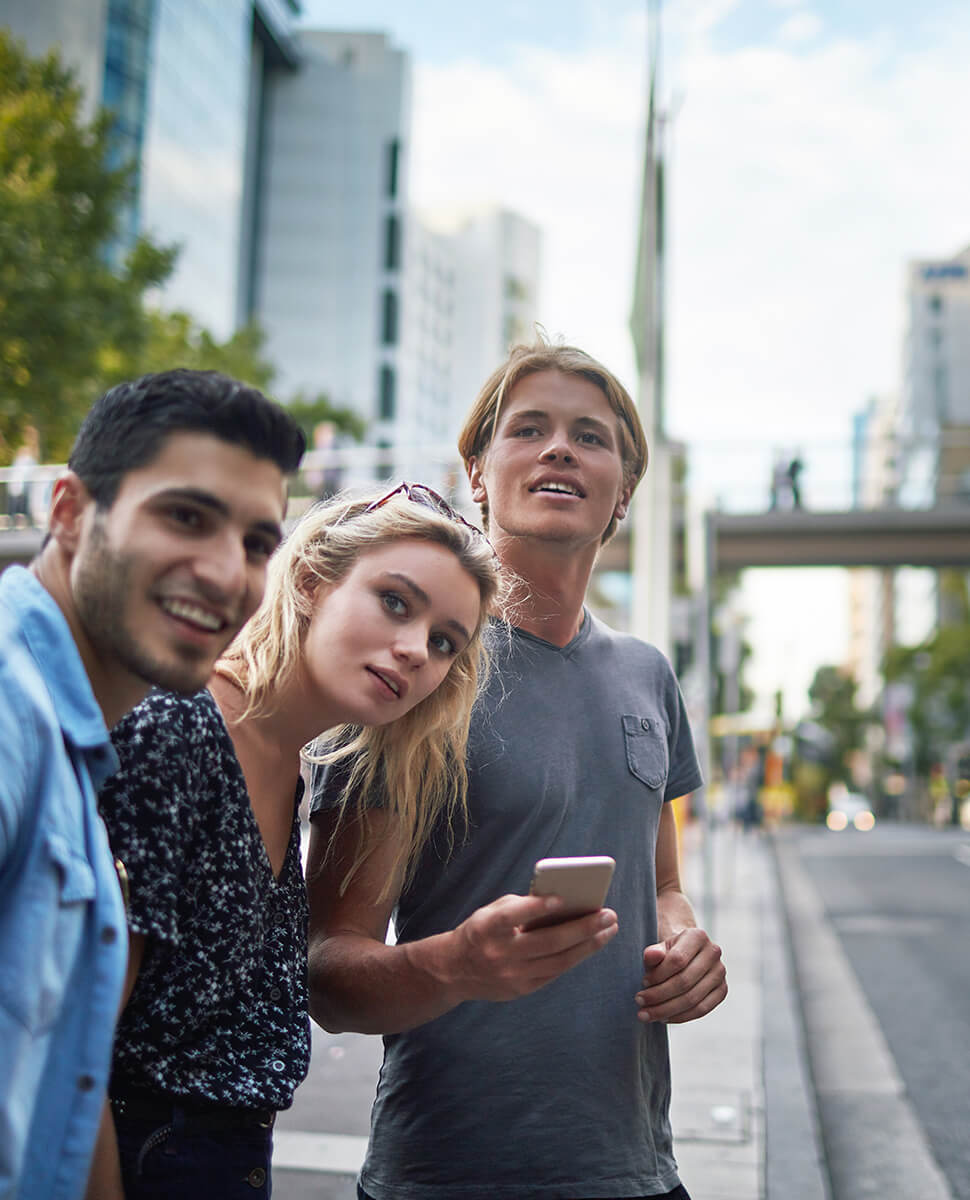 Three people on the side of the road waiting for their ride share