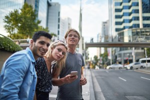 Three millennial young friends waiting for a crowdsourced taxi in Sydney