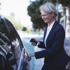Woman getting into a ride share vehicle while smiling