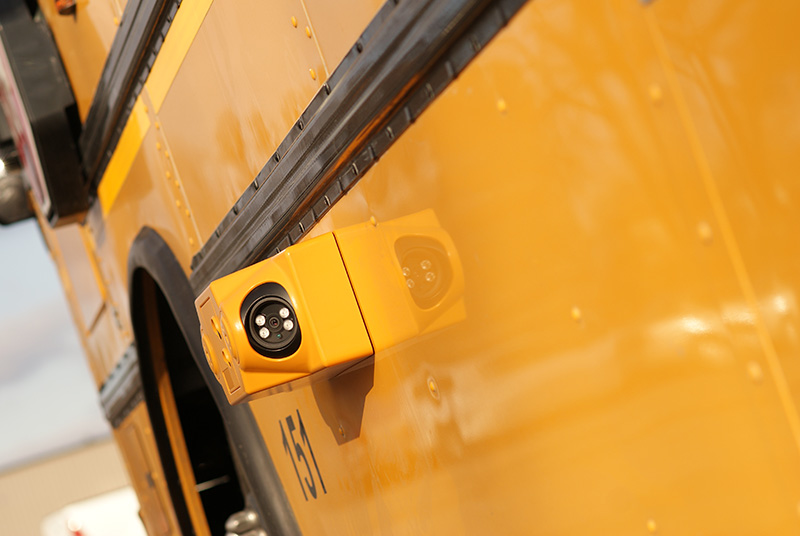 Bus stop arm camera mounted on the side of a school bus.