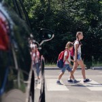 Two children crossing street at an intersection.