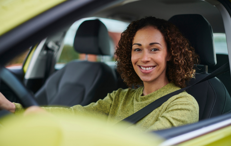 Woman driving car smiling