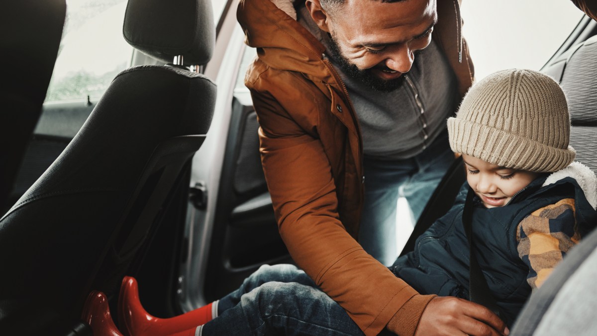 Father helping child with seat belt for safety traveling on vacation,