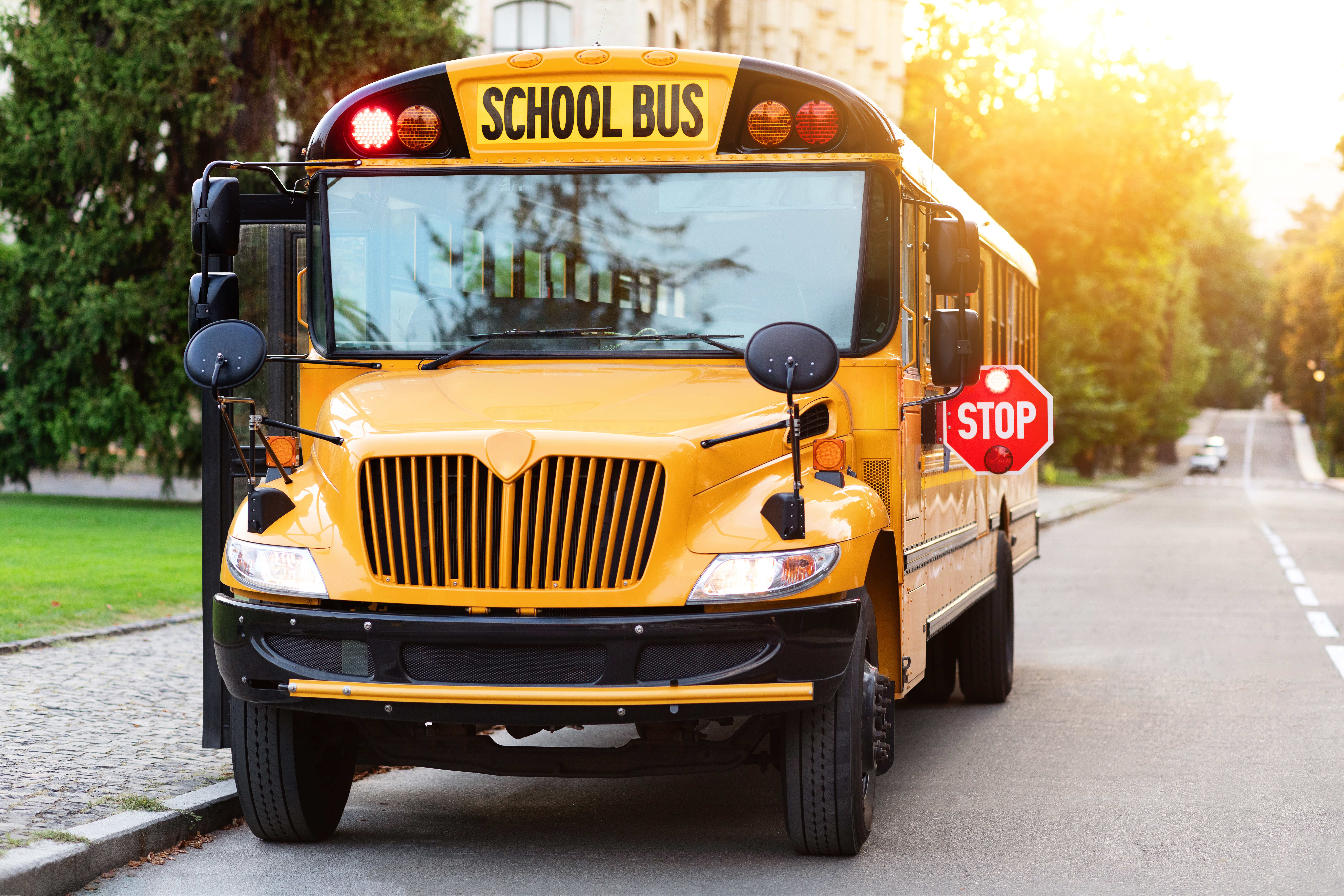 Old-fashioned yellow school bus with red stop sign on the side